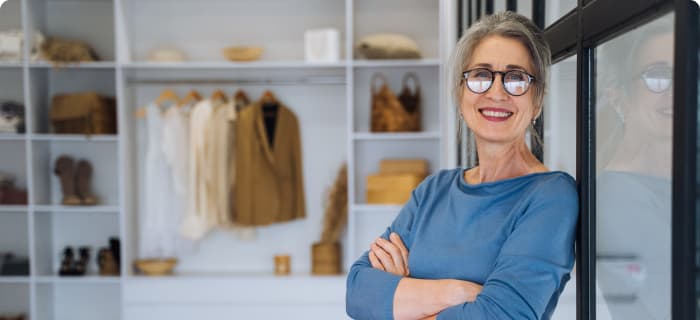 A boutique owner with arms folded, smiling at the camera.